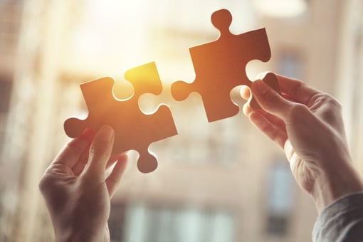 Person putting puzzle pieces together