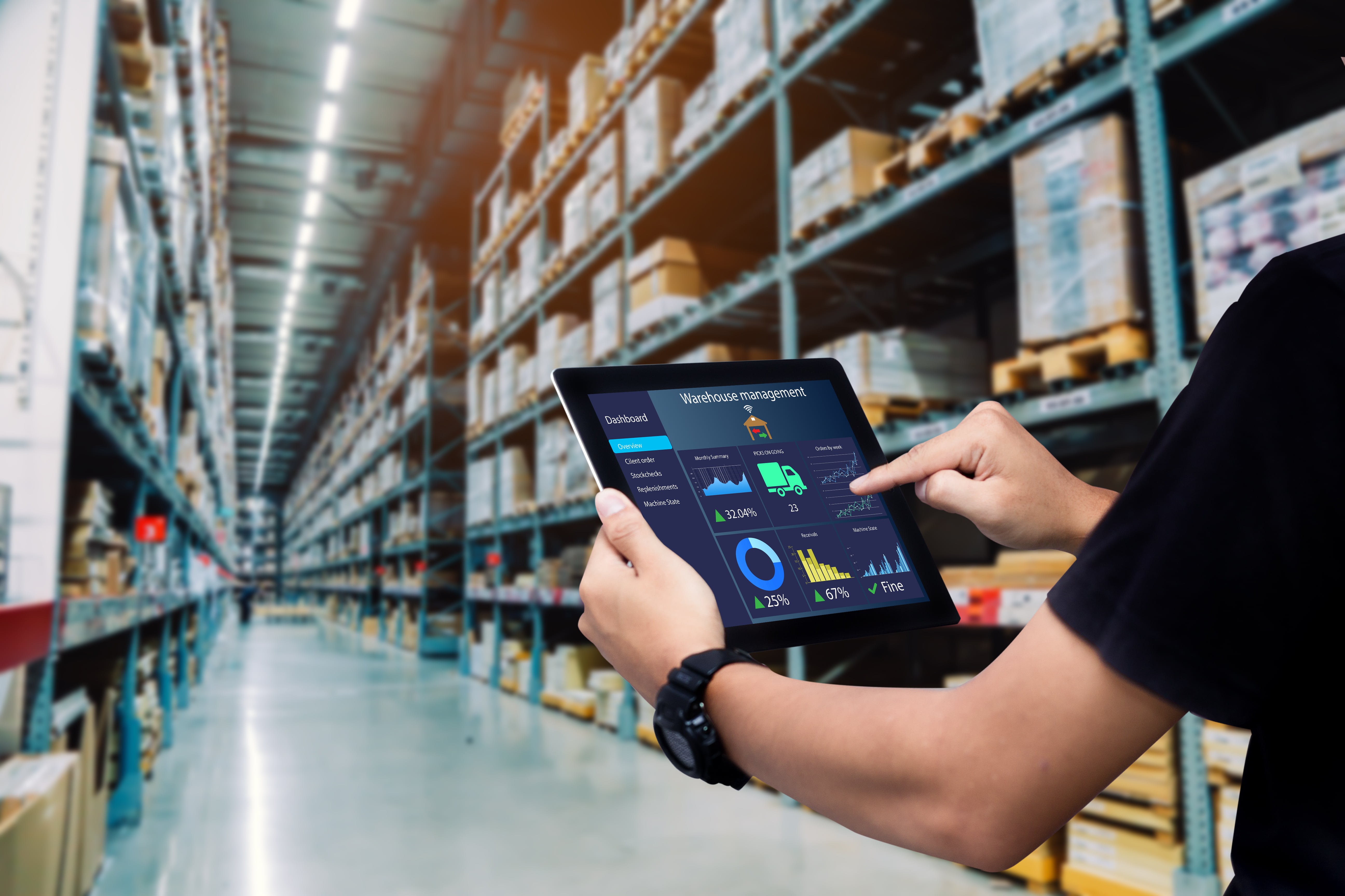 Warehouse worker looking at iPad screen that says "warehouse management"